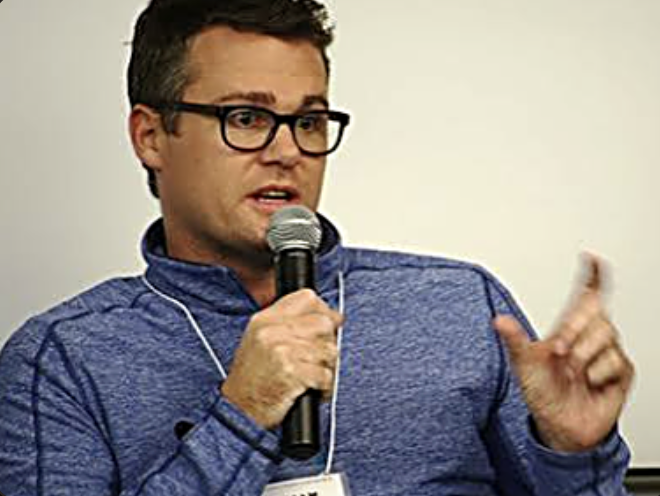 William Skelley speaking into a microphone